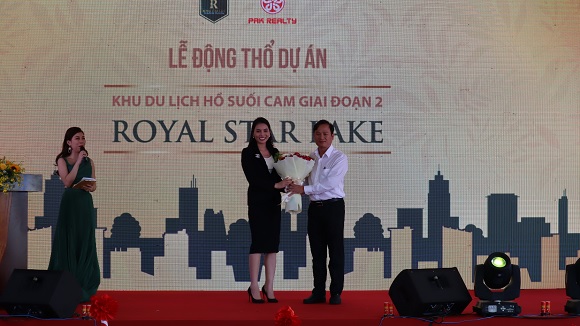 Đại diện chủ đầu tư dự án khu du lịch hồ Suối Cam giai đoạn 2 tặng hoa cho chủ tịch UBND thành phố Đồng Xoài Nguyễn Minh Bình.